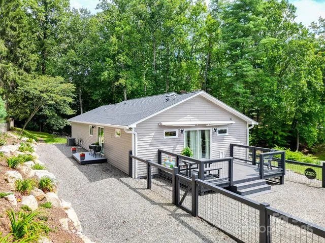 a view of a house with a deck and wooden fence