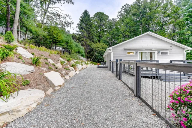 a view of a patio with table and chairs potted plants and large tree