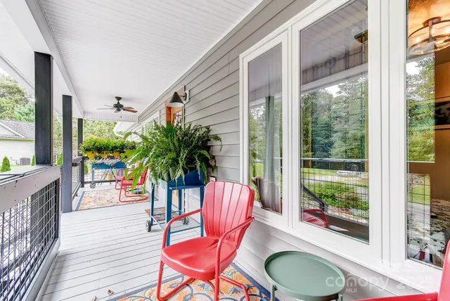 a view of a patio with a table chairs and a floor to ceiling window