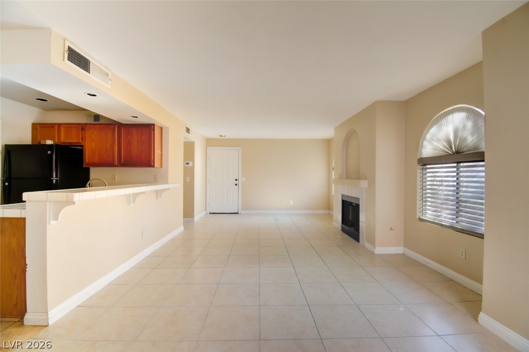 7570 West Flamingo Road, Unit 119 Las Vegas, NV 89147 - Photo 3 of 15 An inviting open-concept living space features a cozy fireplace and convenient kitchen access.