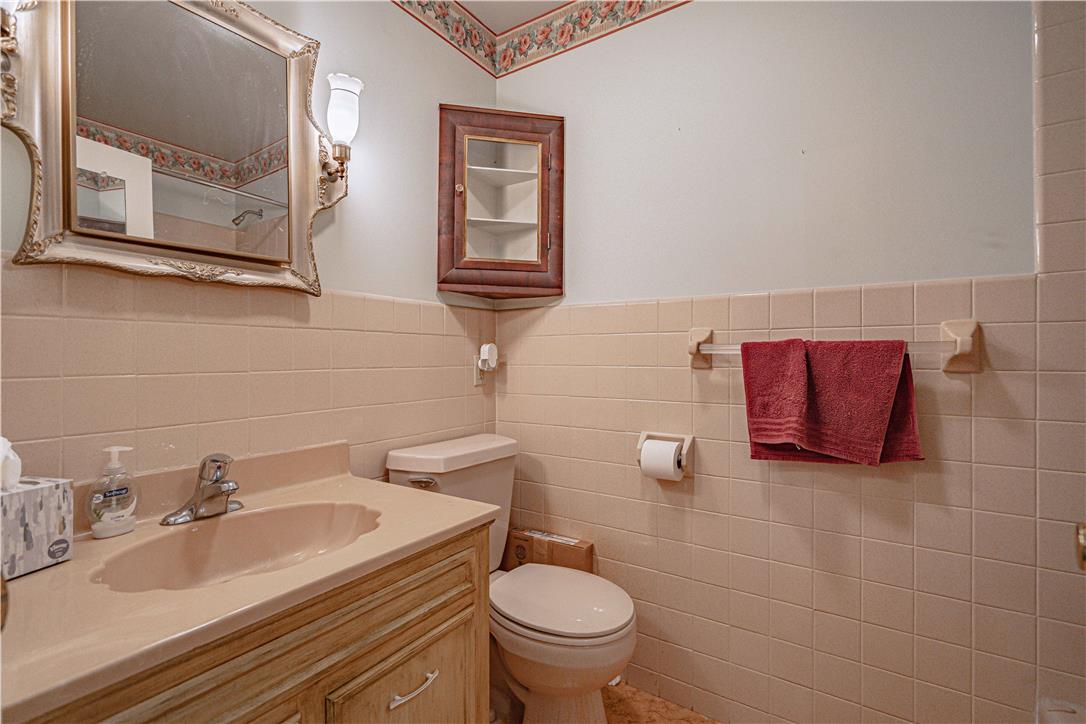 4815 Mill Road Schnecksville, PA 18078 - Photo 24 of 48 A well-lit powder room offers functional tile walls and a stylish framed mirror.