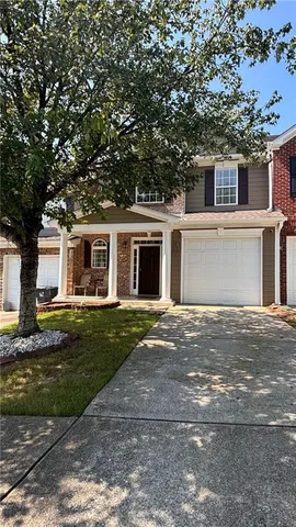 a front view of a house with a yard and a garage