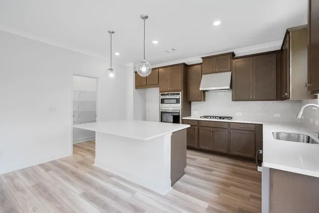 a kitchen with a sink center island and wooden floor