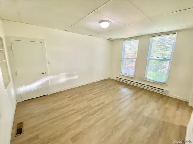 a view of empty room with wooden floor