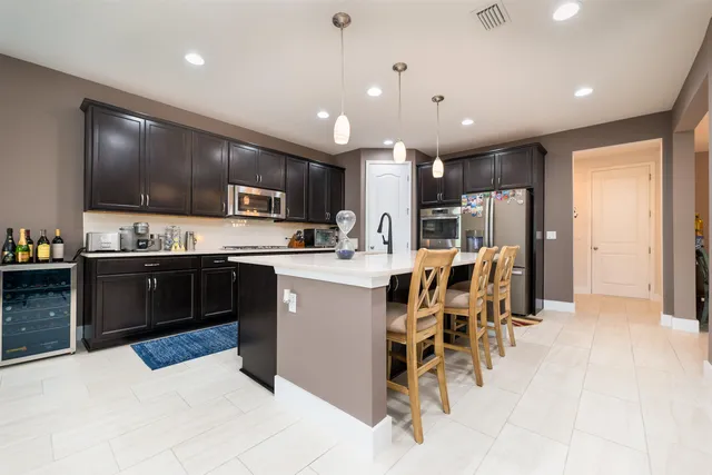 a large kitchen with stainless steel appliances kitchen island a large counter space a sink and cabinets