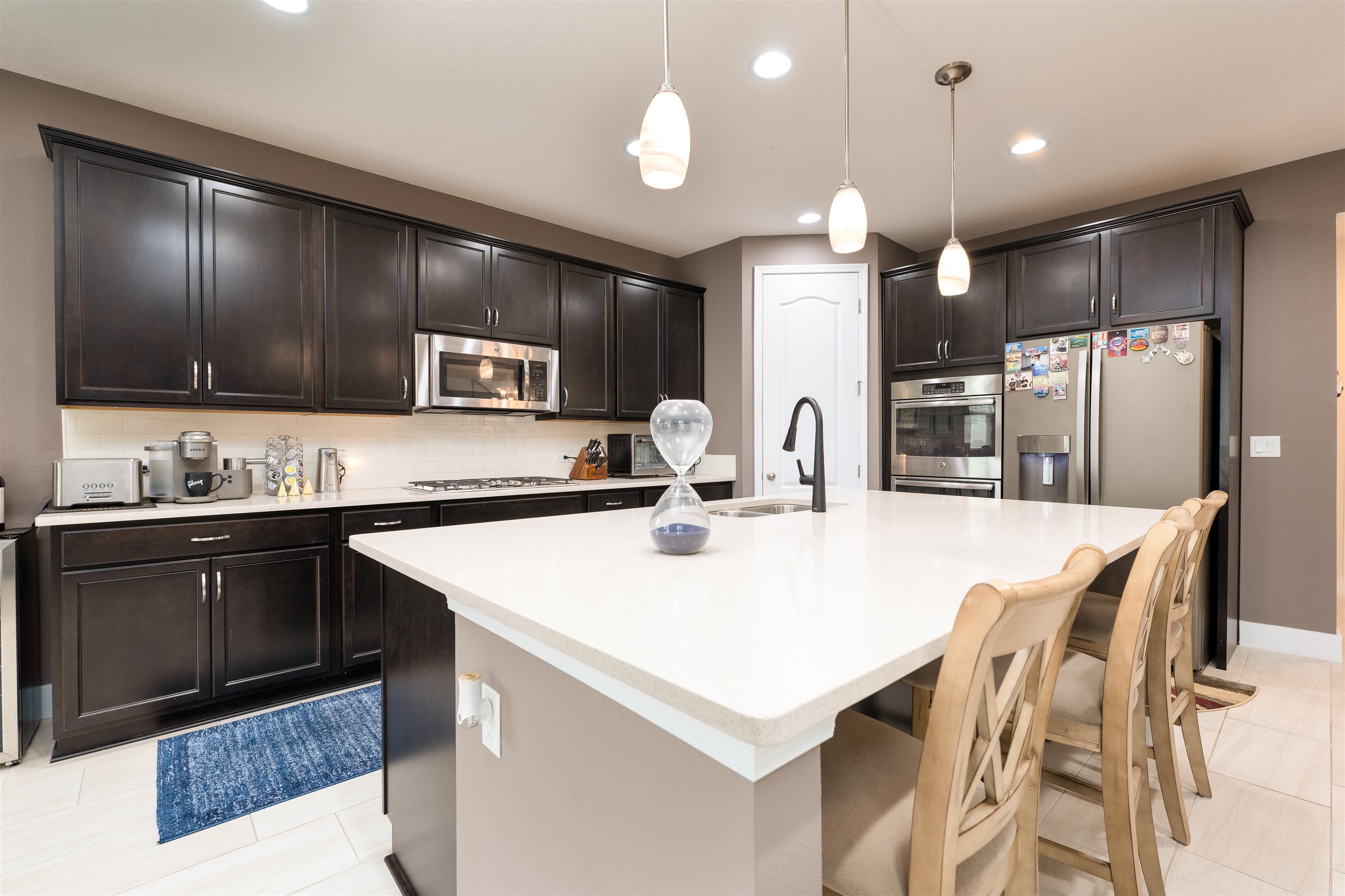 392 Downs Corner Road St. Augustine, FL 32092 - Photo 14 of 55 a kitchen with stainless steel appliances kitchen island granite countertop a sink a stove a refrigerator and island with wooden floor