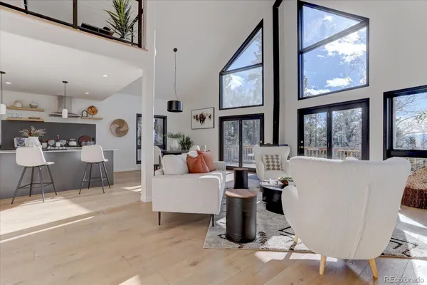 a living room with furniture a large window and flat screen tv