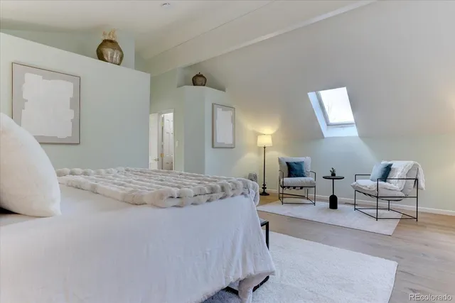 a spacious bedroom with a bed a table and chair