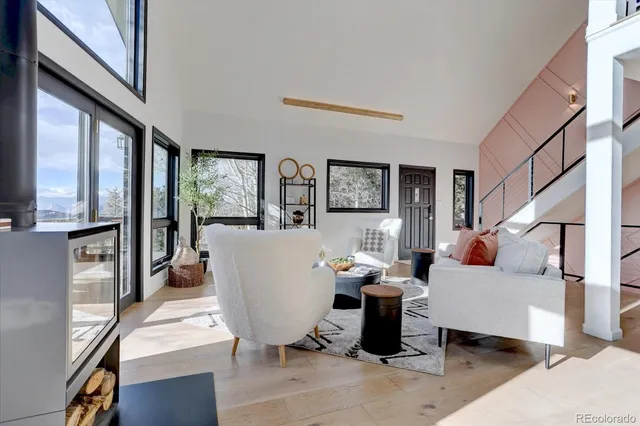 a living room with furniture a large window and kitchen view