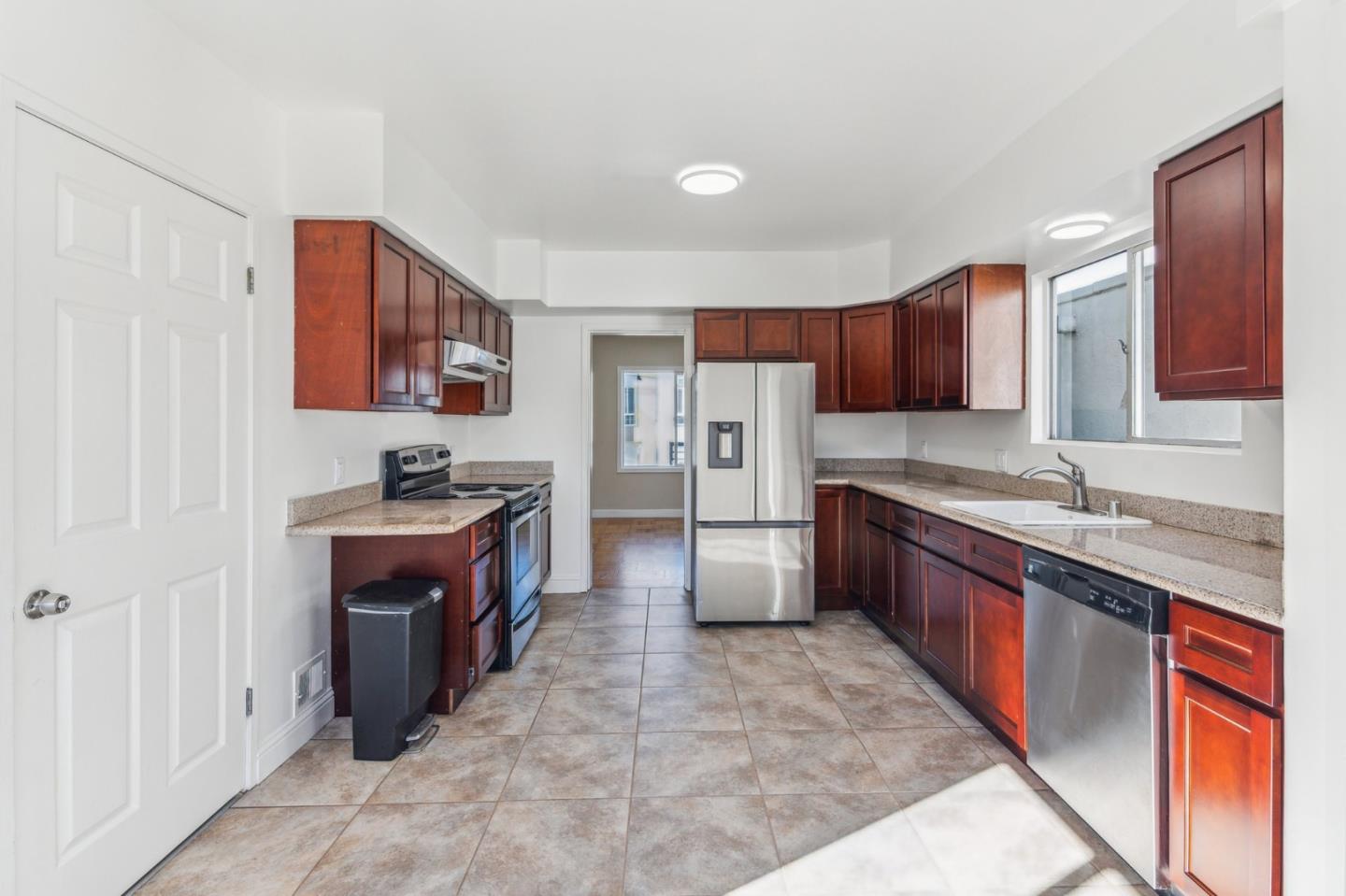 136 Chester Street Daly City, CA 94014 - Photo 19 of 48 a large kitchen with stainless steel appliances granite countertop a stove top oven a sink and dishwasher a oven with wooden cabinets