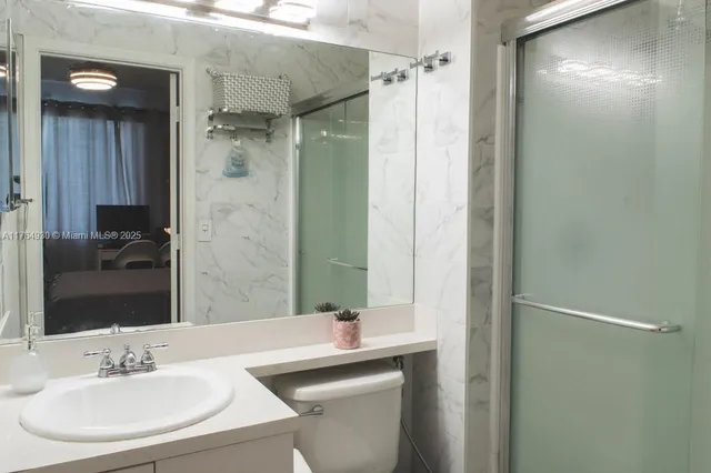 a bathroom with a sink mirror and a shower