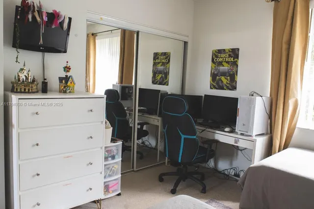 a view of a workspace with furniture and a window