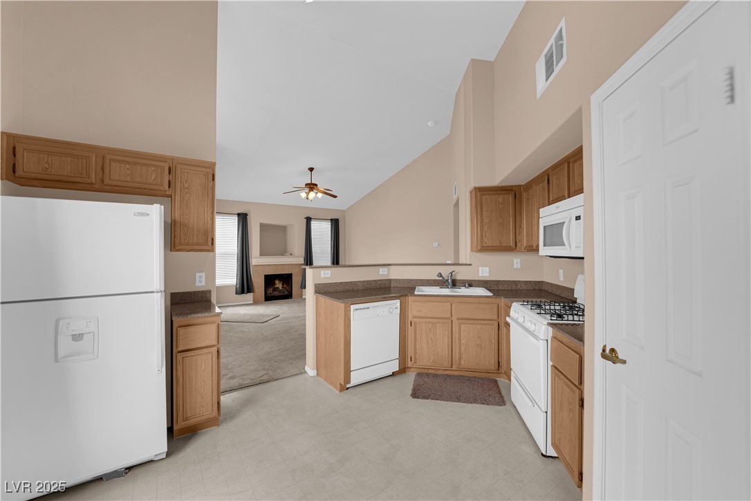 10550 West Alexander Road, Unit 2233 Las Vegas, NV 89129 - Photo 9 of 35 Kitchen featuring a ceiling fan, high vaulted ceiling, a sink, visible vents, and white appliances
