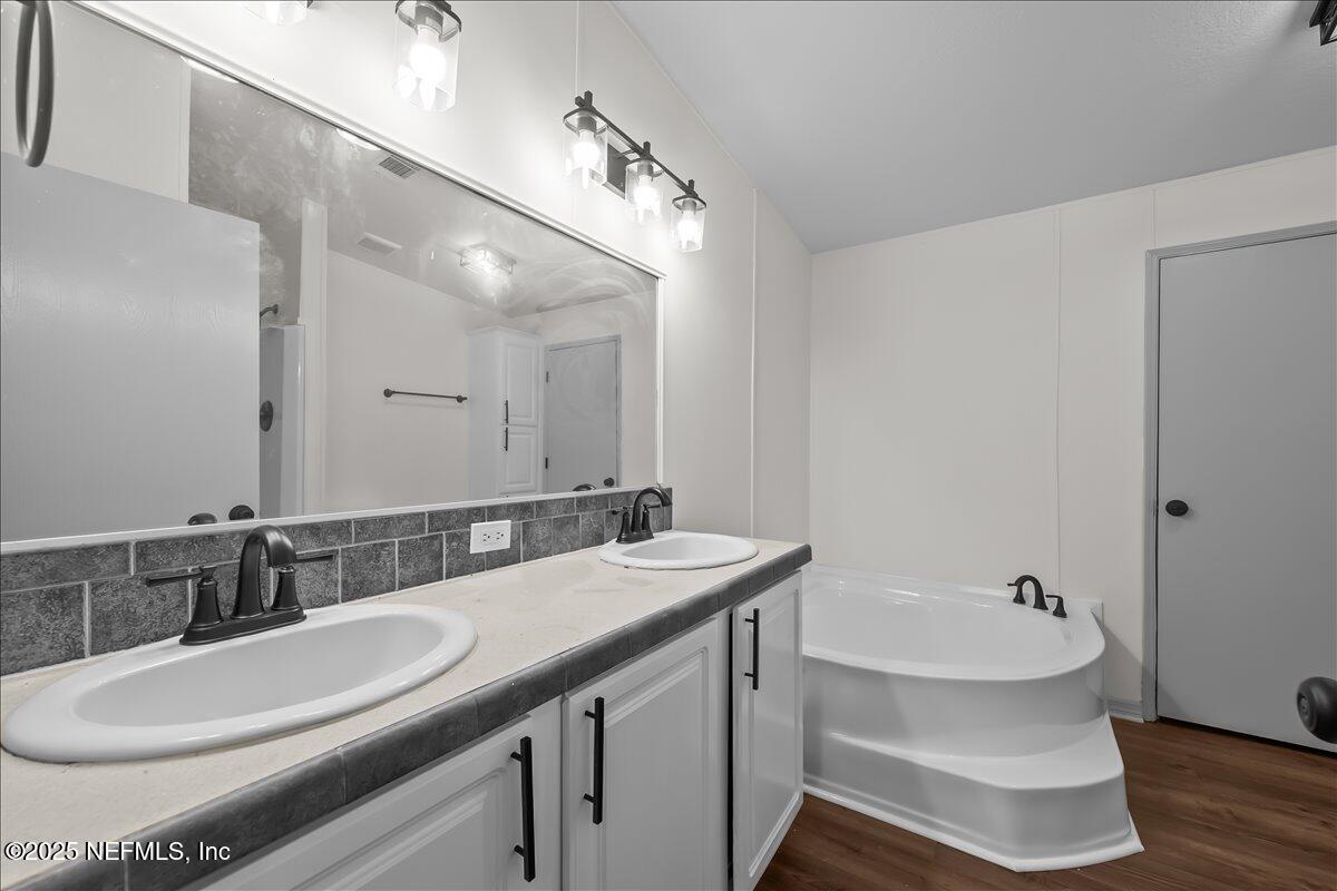 2929 Persimmon Street Bunnell, FL 32110 - Photo 11 of 28 a bathroom with a sink a toilet a mirror and bathtub