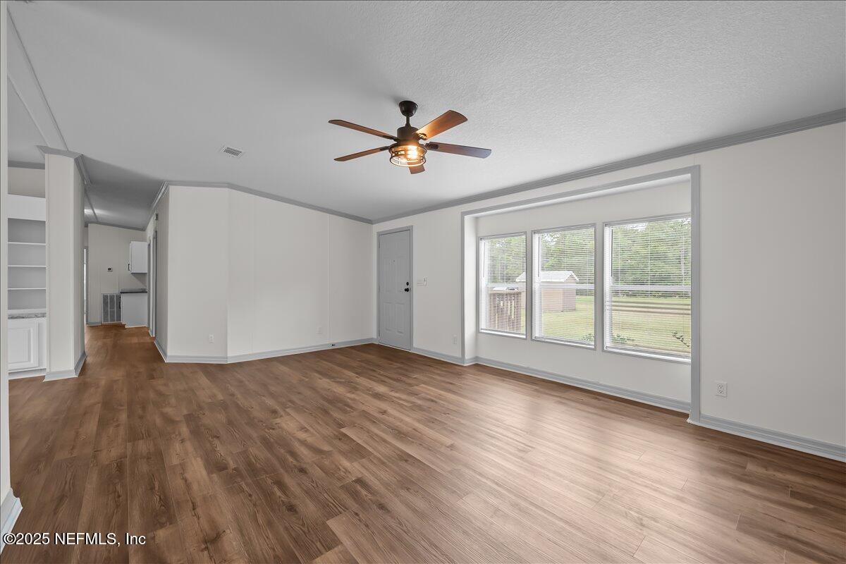 2929 Persimmon Street Bunnell, FL 32110 - Photo 2 of 28 a view of empty room with wooden floor and fan