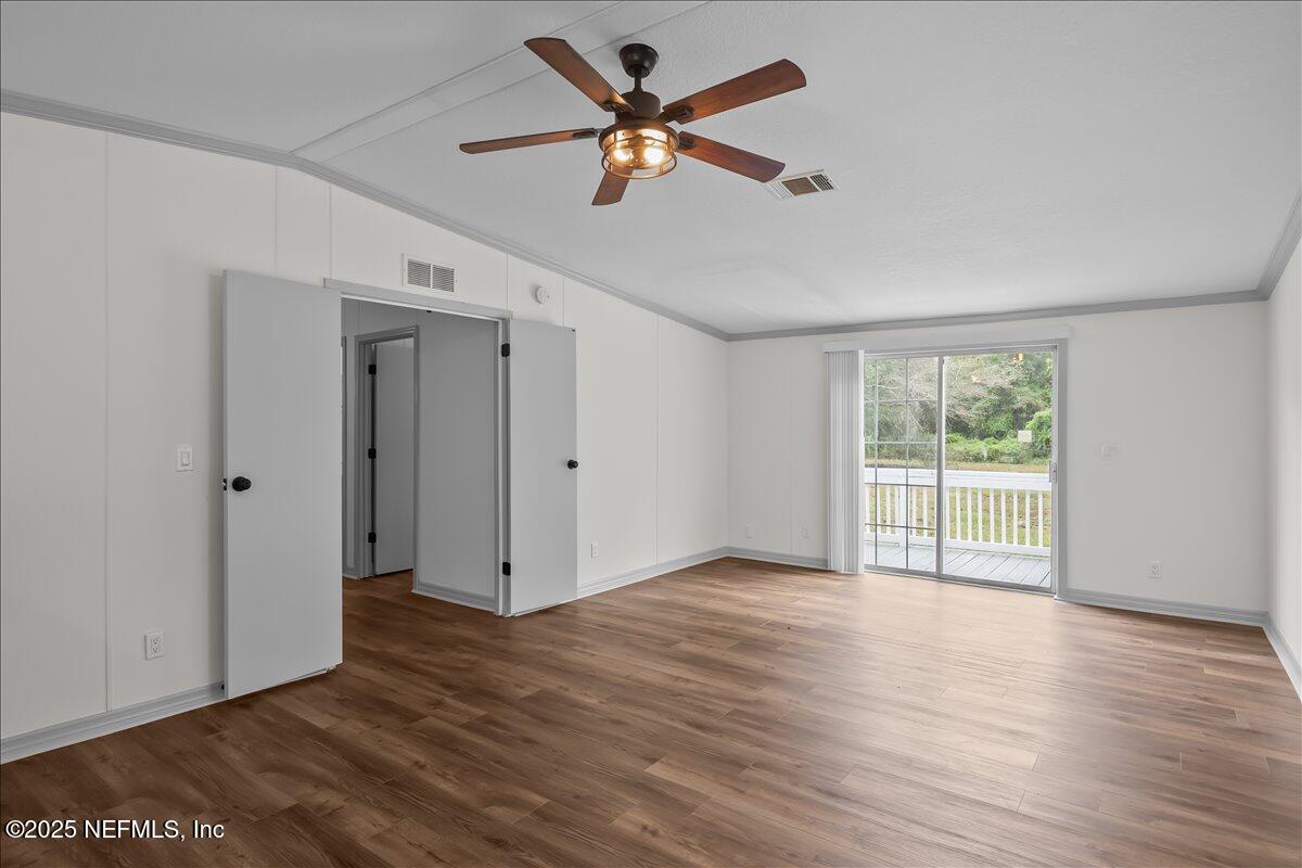 2929 Persimmon Street Bunnell, FL 32110 - Photo 24 of 28 a view of an empty room with wooden floor and a window