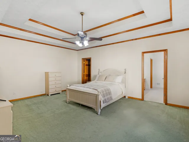 a spacious bedroom with a bed and a chandelier