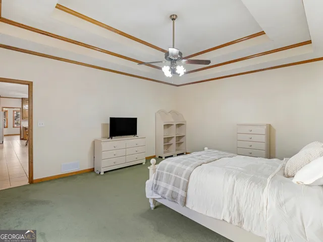 a spacious bedroom with a bed and a ceiling fan