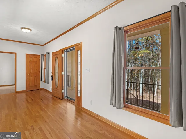 a view of a hallway with wooden floor and windows