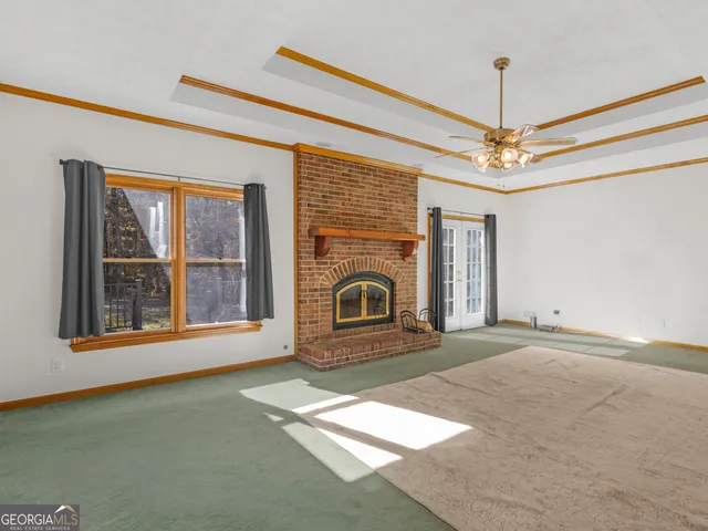 a view of a livingroom with a fireplace and windows