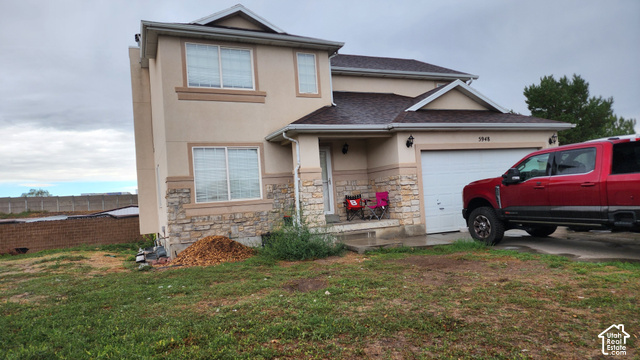 5948 Inheritance Court Taylorsville, UT 84123 - Photo 3 of 30 Stucco exterior with stone accent siding, attached garage, and covered front entry