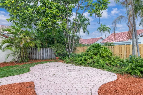 a view of backyard with swimming pool and trees