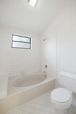 a white toilet sitting next to a bath tub