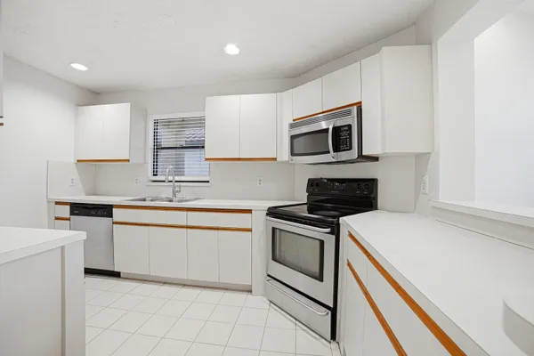 a kitchen with granite countertop cabinets stainless steel appliances and a sink
