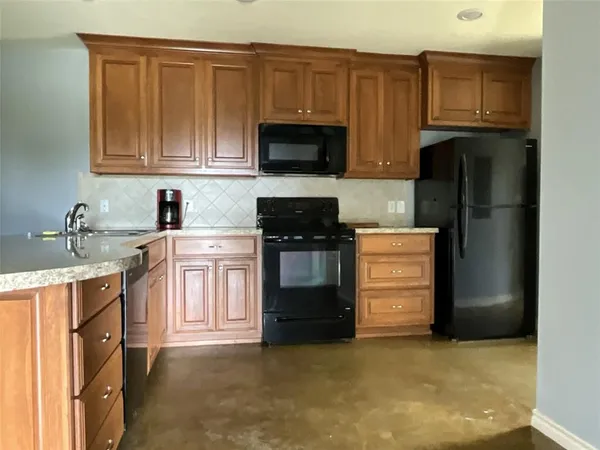 a kitchen with stainless steel appliances granite countertop a refrigerator stove and sink
