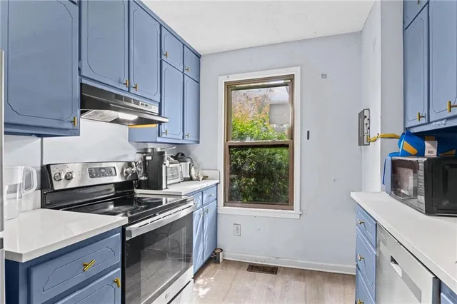 a kitchen with stainless steel appliances a stove a microwave and cabinets