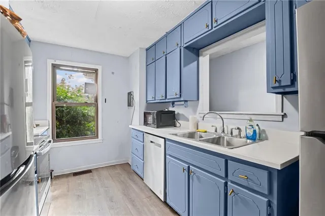 a kitchen with a sink cabinets appliances and a window