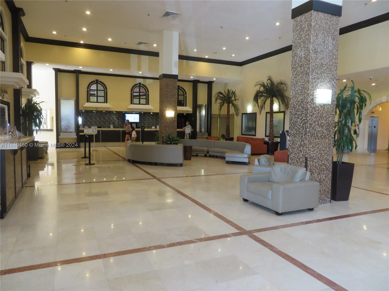 a lobby with furniture and a large mirror
