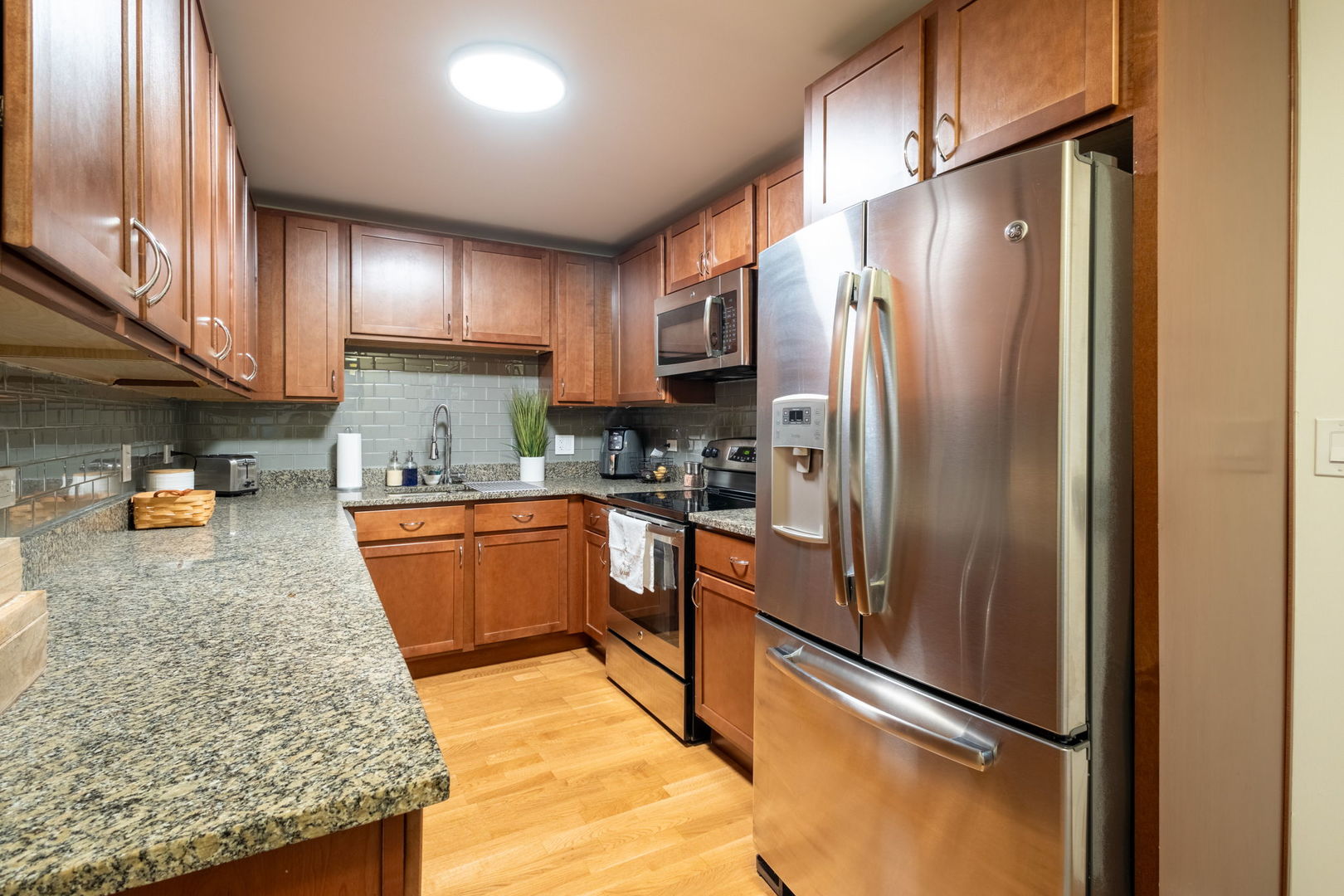 3033 North Sheridan Road, Unit 1203 Chicago, IL 60657 - Photo 8 of 22 a kitchen with stainless steel appliances granite countertop a refrigerator a stove and a sink