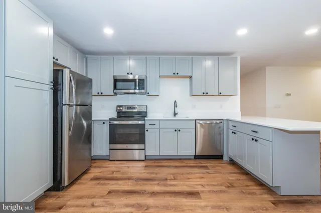 a kitchen with cabinets stainless steel appliances and a window