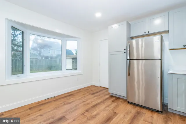 a view of empty room with wooden floor and window