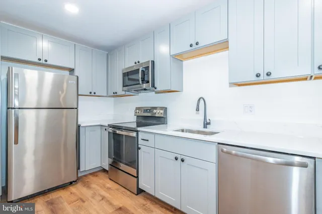 a kitchen with stainless steel appliances a refrigerator sink and cabinets