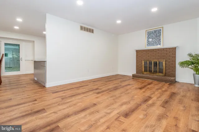 a view of empty room with wooden floor and fireplace