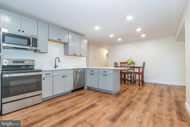 a kitchen with stainless steel appliances a sink a stove a microwave and cabinets