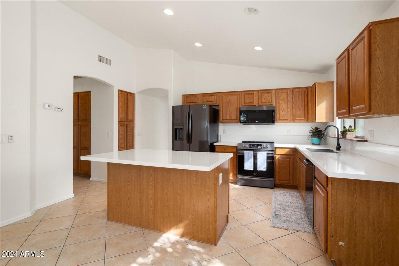 13379 West Boca Raton Road Surprise, AZ 85379 - Photo 6 of 37 a kitchen with stainless steel appliances a stove a sink a refrigerator and a refrigerator