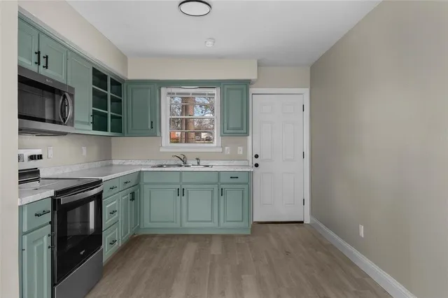 a kitchen with a sink stove top oven and cabinets