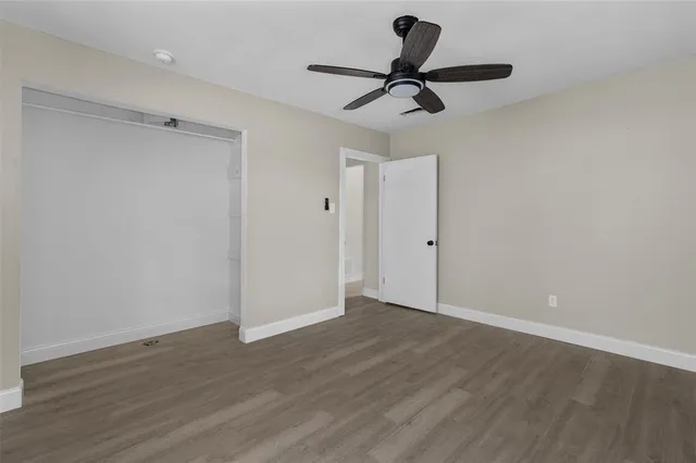 a view of a room with wooden floor closet and windows