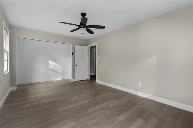 a view of a big room with wooden floor closet and windows