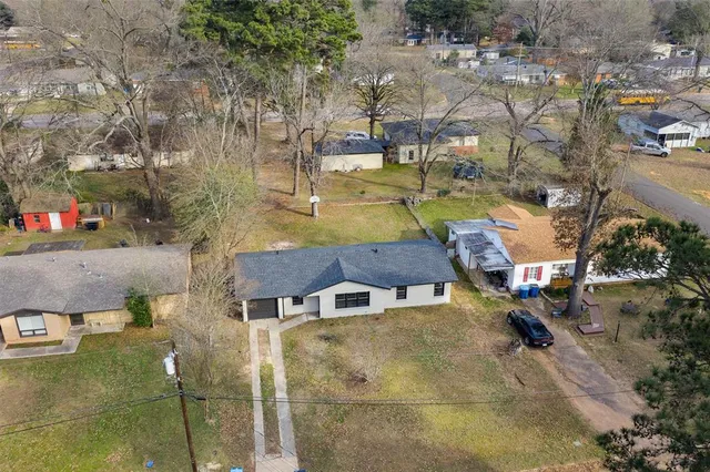 an aerial view of a house with a yard basket ball court and outdoor seating