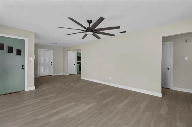 a view of a big room with wooden floor and windows
