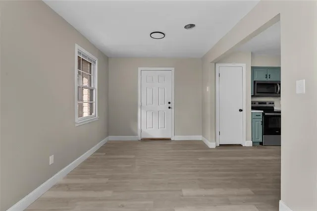 a view of an empty room with closet and a window