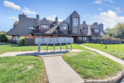 a view of a house with a big yard and a large tree