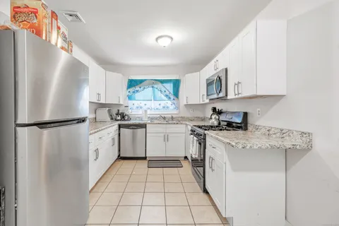 a kitchen with a white cabinets and white appliances