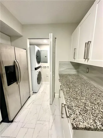 a kitchen with stainless steel appliances granite countertop a sink a stove and a refrigerator