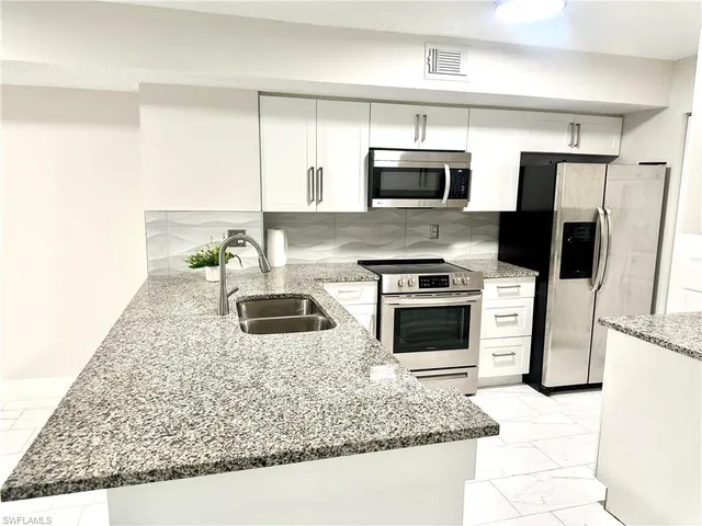 a large white bathroom with a granite countertop sink