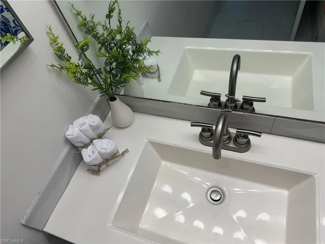 a bathroom with a sink vanity mirror and toilet